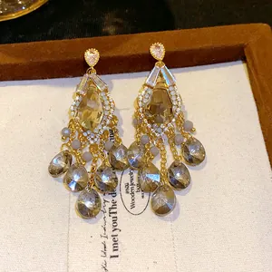 Detail view of elegant tassel earrings featuring zircon studs and faceted glass beads.