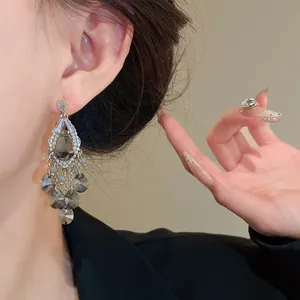 Close-up detail of elegant zircon and dark grey water drop glass bead chandelier earrings