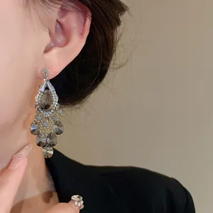 Detailed view of silver needle zircon tassel earrings with smoky grey teardrop glass beads