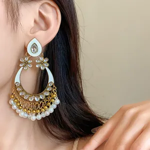 Close-up of ethnic style teardrop earrings with pearl fringe and crystal flowers