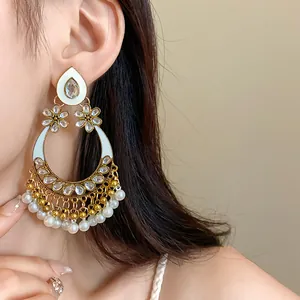 Close-up of elegant bohemian drop earrings with teardrop flower and pearl details on ear