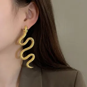 Boucles d'oreilles serpent dorées surdimensionnées avec écailles texturées