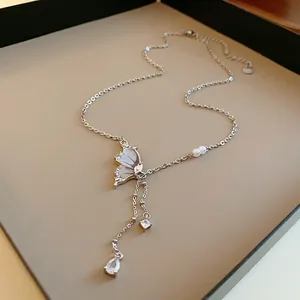 Elegant silver-tone butterfly necklace with pearls and sparkling crystal charms detail.