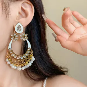 Close-up of vintage ethnic style pearl earrings with rhinestones and white enamel