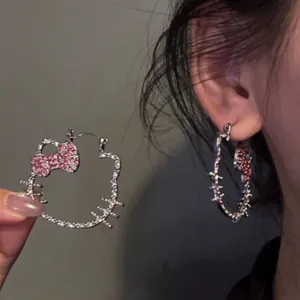 Orecchini a cerchio Hello Kitty in argento con fiocco in strass rosa indossati sull'orecchio