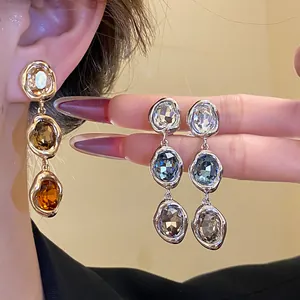 Detail view of vintage style 18k gold plated oval crystal tassel drop earrings