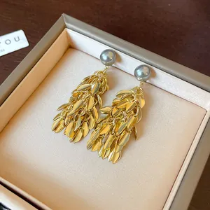 Elegant gold leaf tassel earrings with grey pearls showcased in a luxury jewelry box