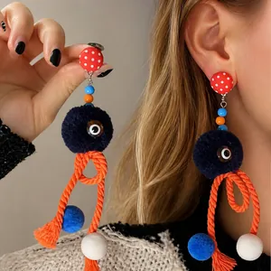 Detail van eigenzinnige octopus oorbellen met rode stippen en een oranje touwtje