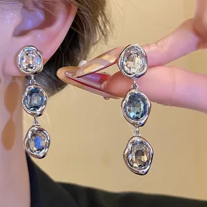 Close-up of 18k gold plated vintage earrings with blue and clear crystal stones