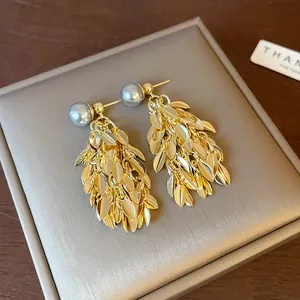 Detailed macro shot of vintage gold leaf tassel earrings with grey faux pearls