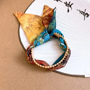 Close-up of artistic ethnic fabric bracelet with Van Gogh style print and gold beaded trim