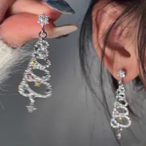 Dettaglio di eleganti orecchini a pendente ad albero di Natale con strass