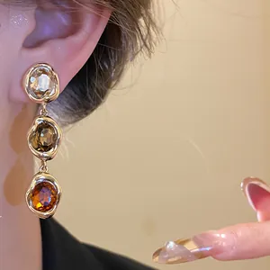 Detailed view of 18k gold plated vintage drop earrings with three faceted oval stones.