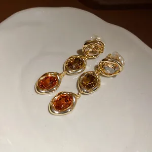 Macro view of vintage-style 18k gold-plated oval amber crystal clip-on earrings