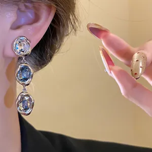 Close-up of elegant vintage silver drop earrings with blue and clear crystal stones.