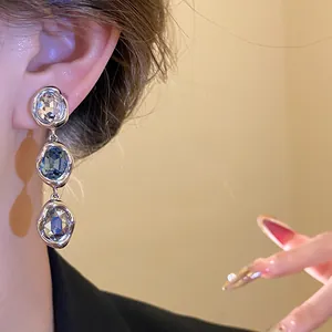 Close-up detail of 18k gold plated oval crystal drop earrings in vintage style