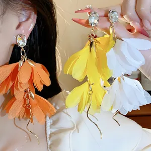 Dettaglio di orecchini a fiori in chiffon a cascata con eleganti perni in cristallo trasparente
