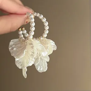 Close-up of elegant French style hoop earrings with pearls and white petal tassels