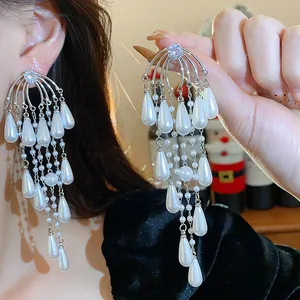 Detalle de pendientes de borla de plata con perlas de gota blancas y circonitas
