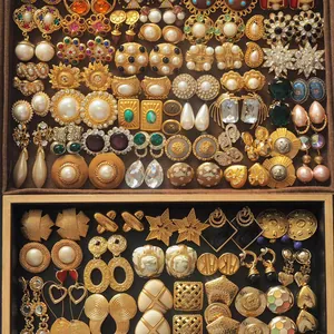 A detailed display showing a variety of vintage French style gold earrings with pearls.