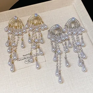 Primer plano de elegantes pendientes de circonita con perlas de gota de agua