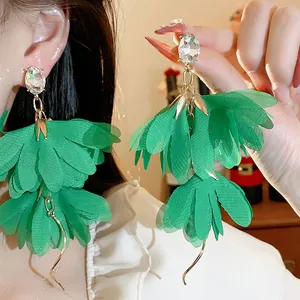 Primo piano di orecchini a fiore in chiffon verde con perni di cristallo