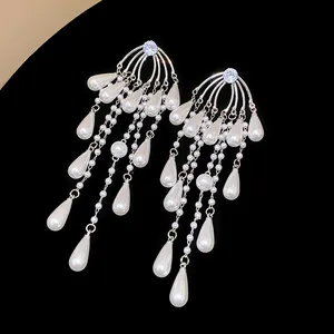 Detalle de primer plano de elegantes pendientes de plata con perlas y circonitas