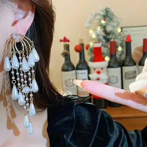 Primer plano detallado de pendientes de borlas de oro y perlas para un look de lujo festivo