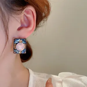 Elegant French vintage geometric stud earrings with blue and pink crystals on model's ear