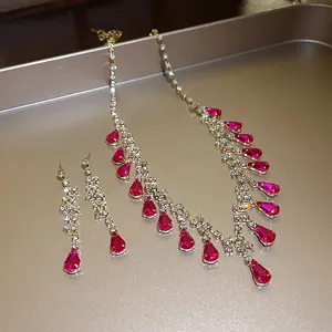 Nahaufnahme eines luxuriösen Schmucksets mit roten Wassertropfen-Strasssteinen und Gold