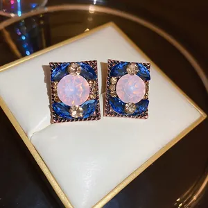 Close-up of vintage French court style rectangular earrings with pink and blue stones