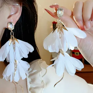 Primo piano di eleganti orecchini a fiore in chiffon bianco con brillanti cristalli