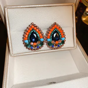 Close-up of vintage French floral teardrop earrings with colorful beads in a gift box