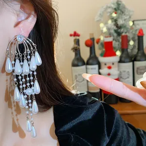 Pendientes de lujo con borlas de perlas y circonitas en forma de gota en una oreja