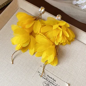 Primo piano dettagliato di eleganti orecchini a fiore in chiffon giallo con cristalli