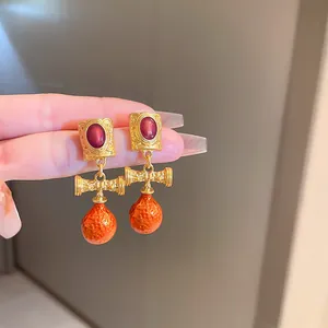 Close-up detail of French vintage court style drop earrings with red oval cabochons