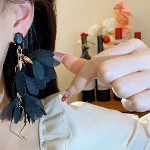 Primo piano dettagliato di eleganti orecchini a nappa con fiori in chiffon nero a più strati