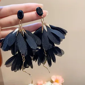Dettaglio orecchini a petalo di fiori in chiffon nero con borchie in pietra ovale nera