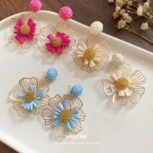Handmade raffia flower drop earrings in pink, blue, and beige for a chic vacation look