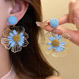 Elegant blue raffia flower dangle earrings with gold-tone petals for vacation style
