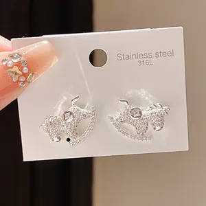 Close-up of crystal rocking horse earrings on a 316L stainless steel card