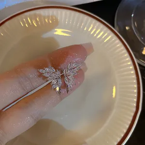 Primo piano dettagliato di un earcuff a farfalla d'argento con cristalli di zircone