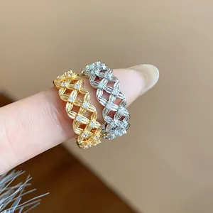 Detailed close-up of two hollow lattice rings with sparkling zircons on a finger