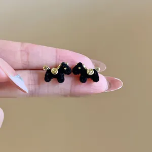Handcrafted black flocked pony stud earrings with gold accents and silver needles