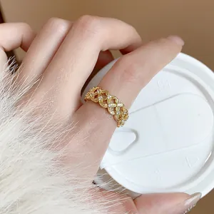 Detailed view of an 18k gold-plated hollow flower ring with sparkling zircons on a hand