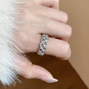 Close-up detail of a silver-toned hollow flower ring set with sparkling zircons on a finger