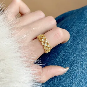 Detailed view of an 18k gold plated hollow lattice ring with sparkling zircons.