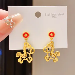 Primo piano di orecchini a cavallo in acciaio inossidabile dorato con smalto rosso su carta