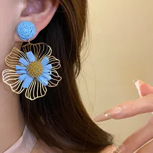 Elegant blue raffia flower pendant earrings with golden wire petals for vacation style.
