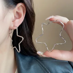 Pendientes de aro con forma de estrella plateados en una modelo para un look moderno.